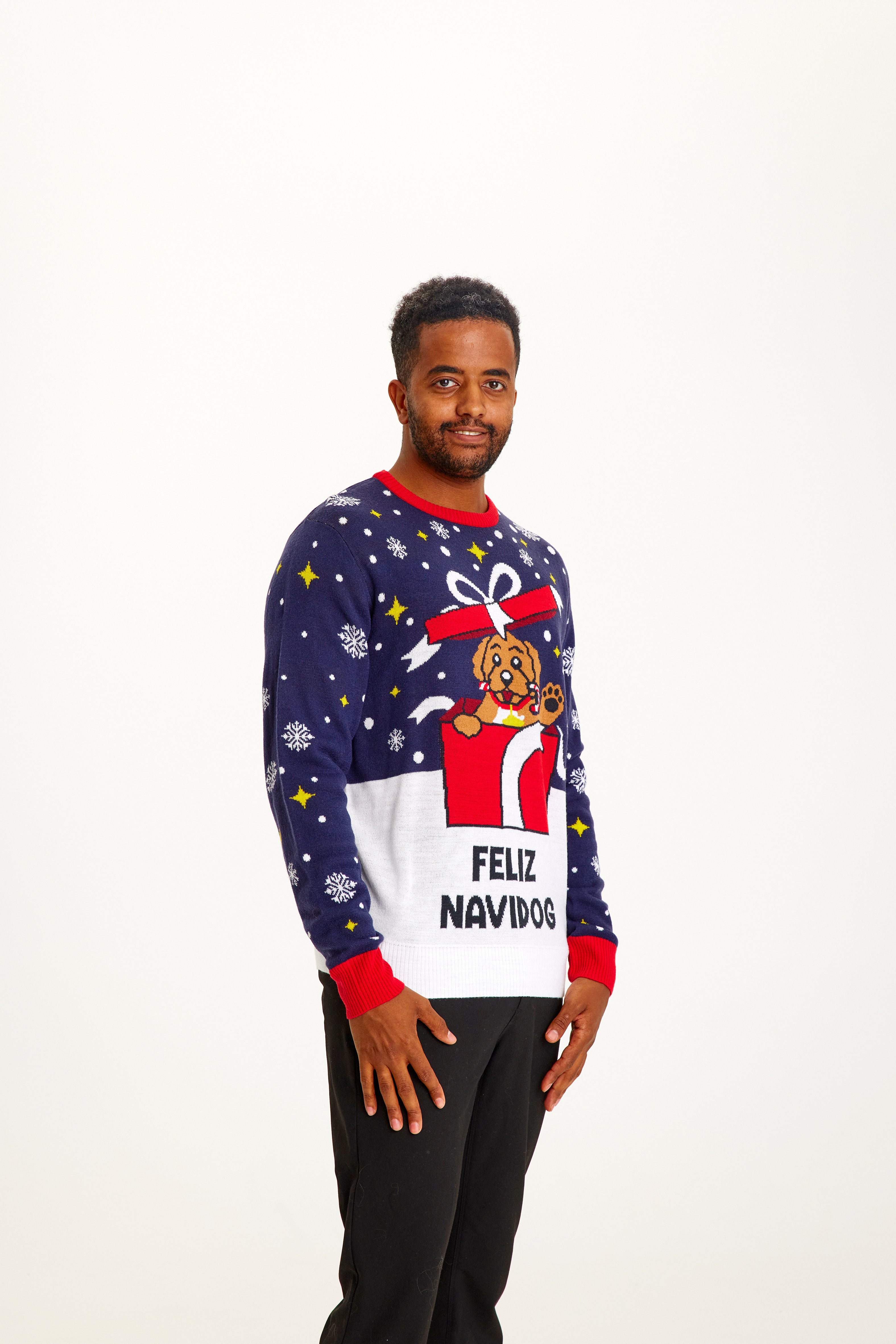 Un homme souriant porte un pull de Noël orné d'un chien.